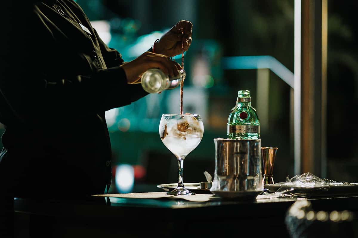 person pouring a cocktail