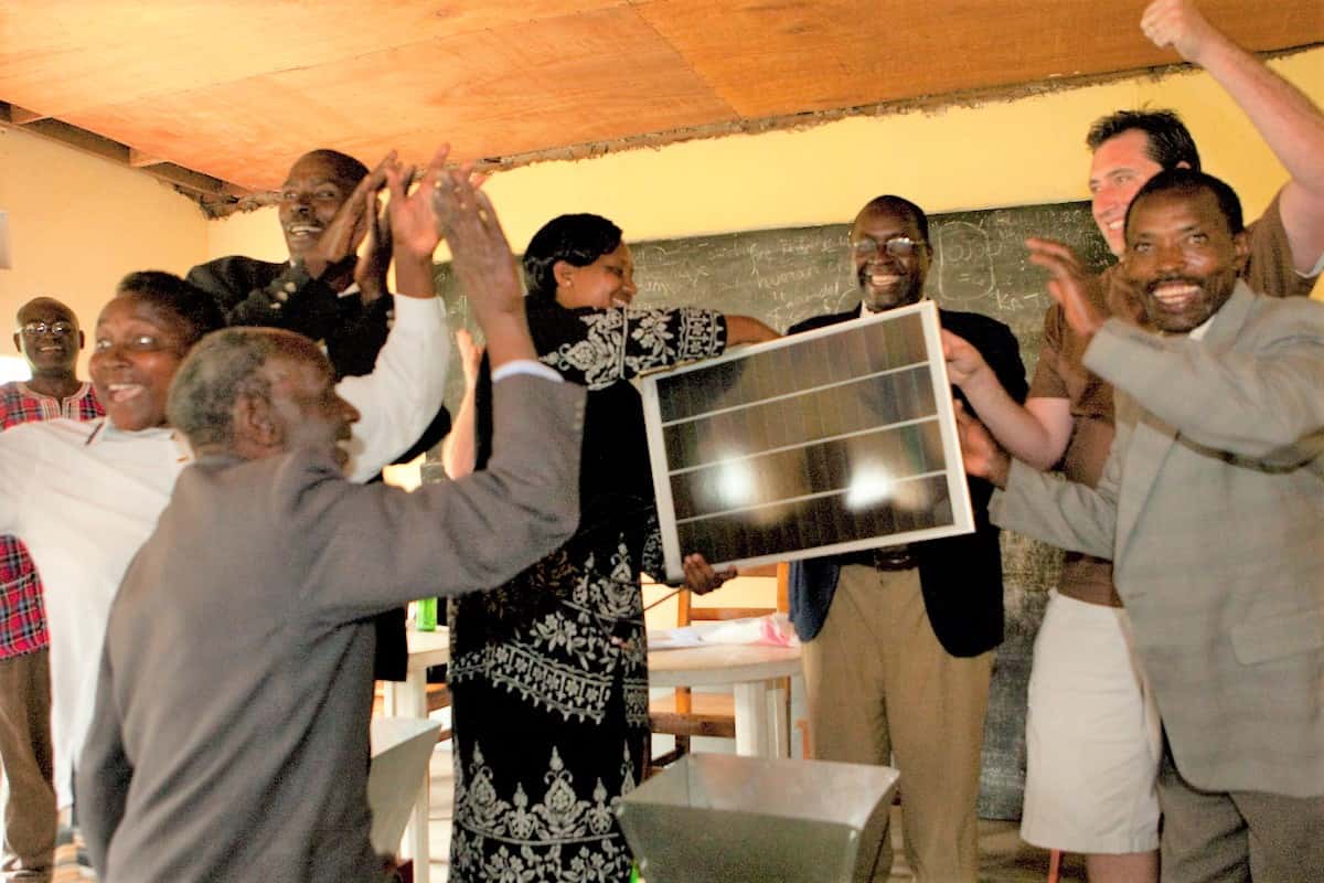 Shallom Berkman and coffee farming families hold up one of the solar panels that Urth Caffé gave and installed s in farm family homes
