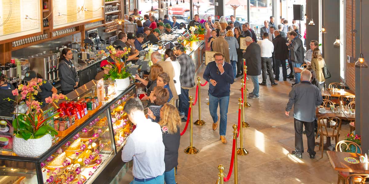 Guests waiting in line to order next to the pastry display cases at Urth Orange