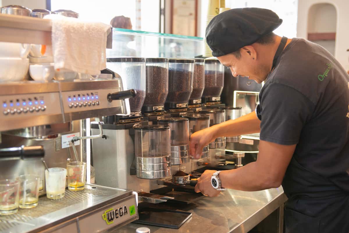 Barista measures espresso beans for a latte
