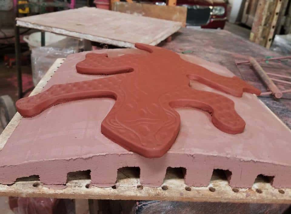 Clay gecko shaped into curve at pottery studio