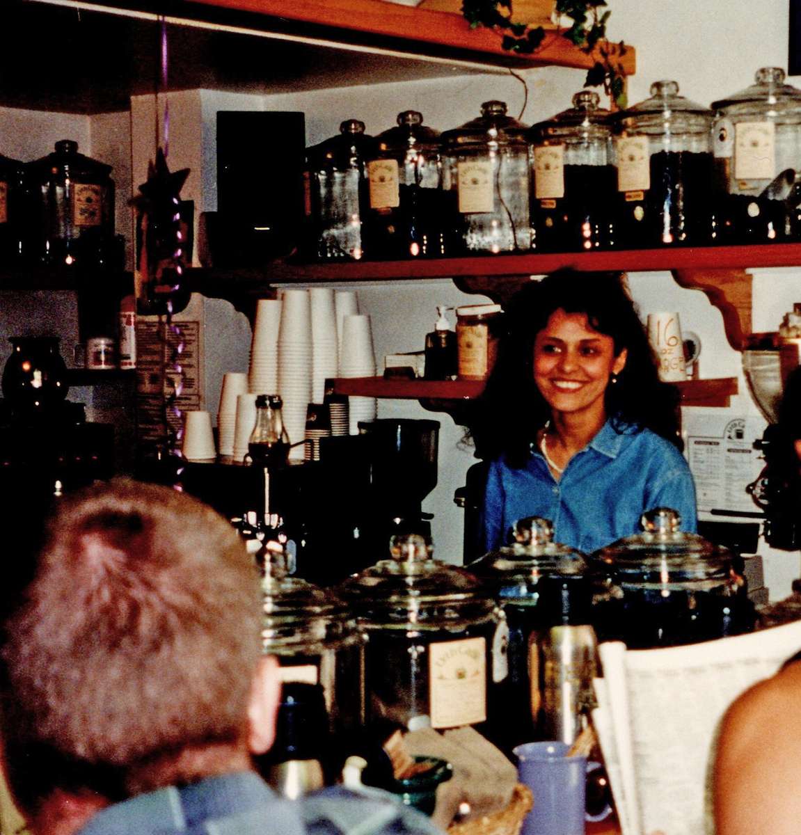 Jilla Berkman stands behind counter at cafe