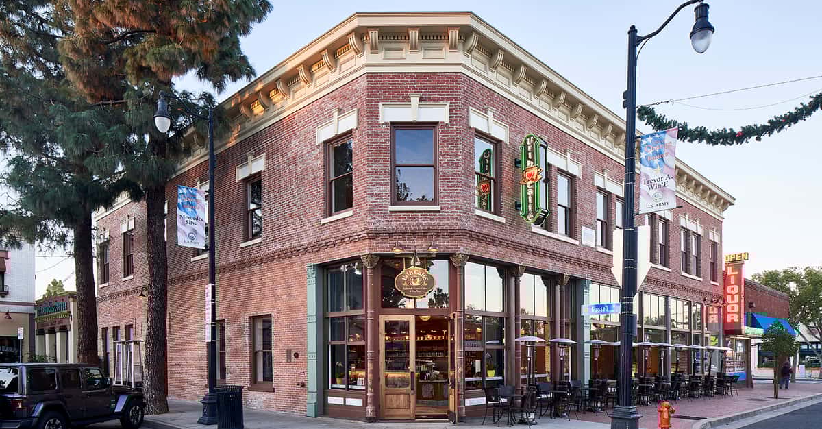 View of corner with restored two story brick building of Urth Caffe Orange