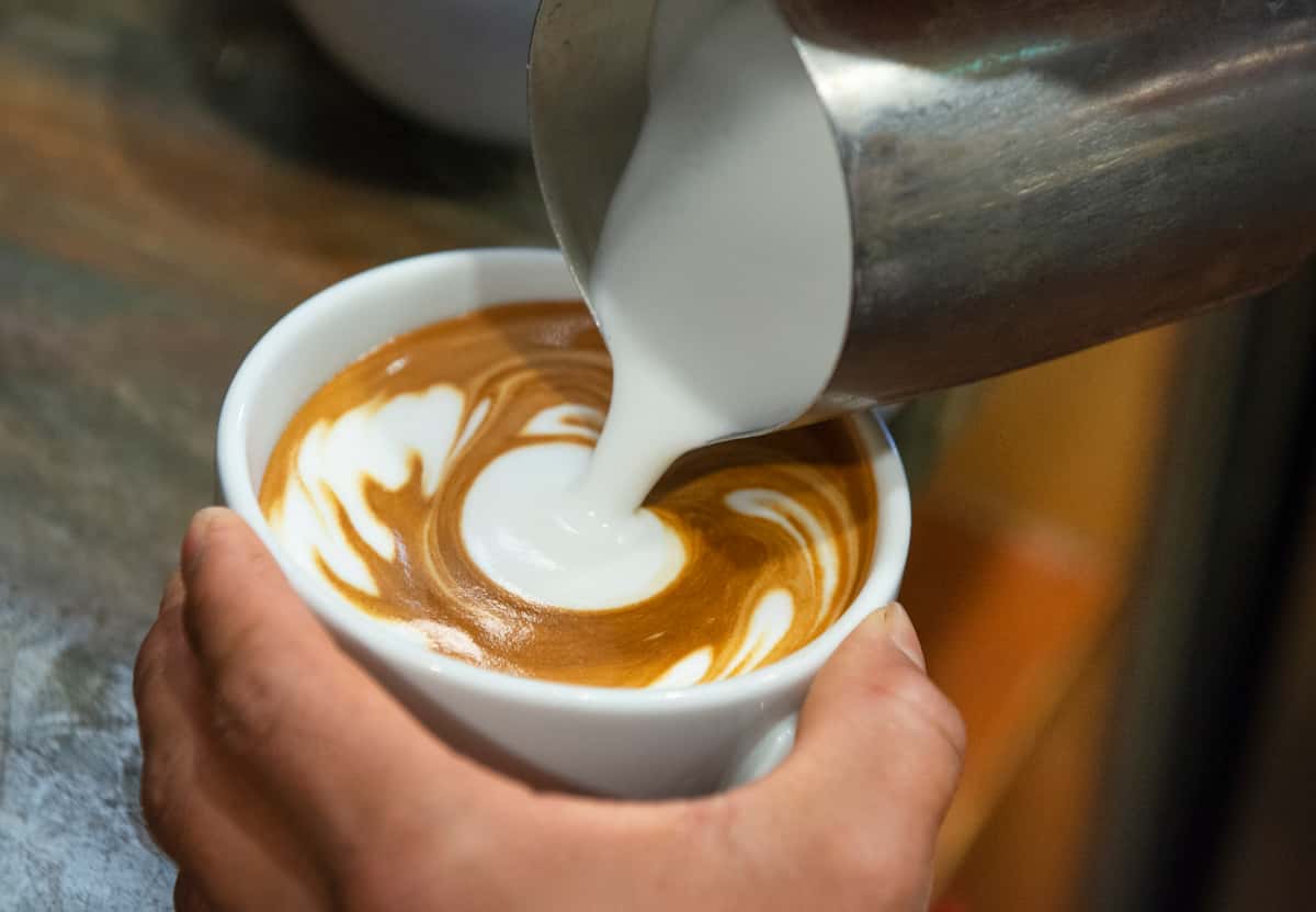 Steamed milk is added to cup of brewed espresso
