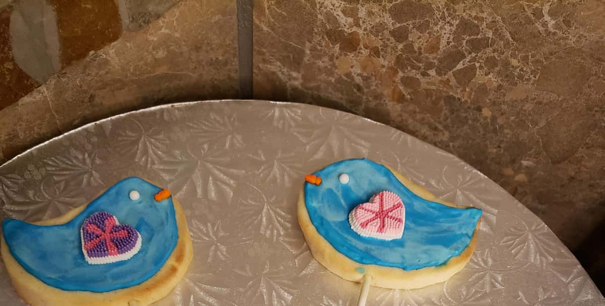 Cookies in the shapes of blue birds with hearts for wings