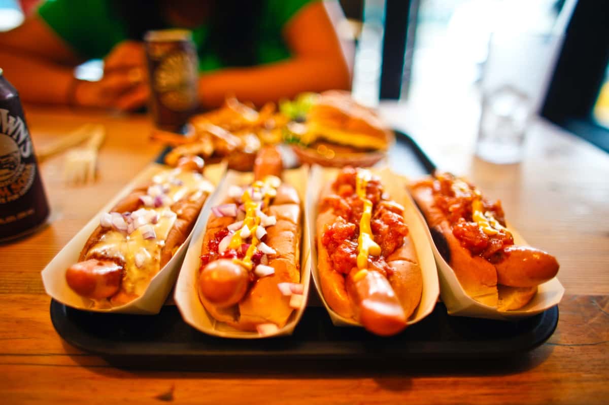 Multiple hot dogs with various condiments