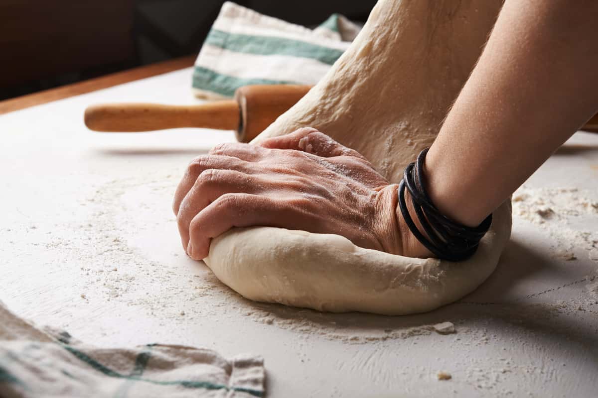 hand on pizza dough