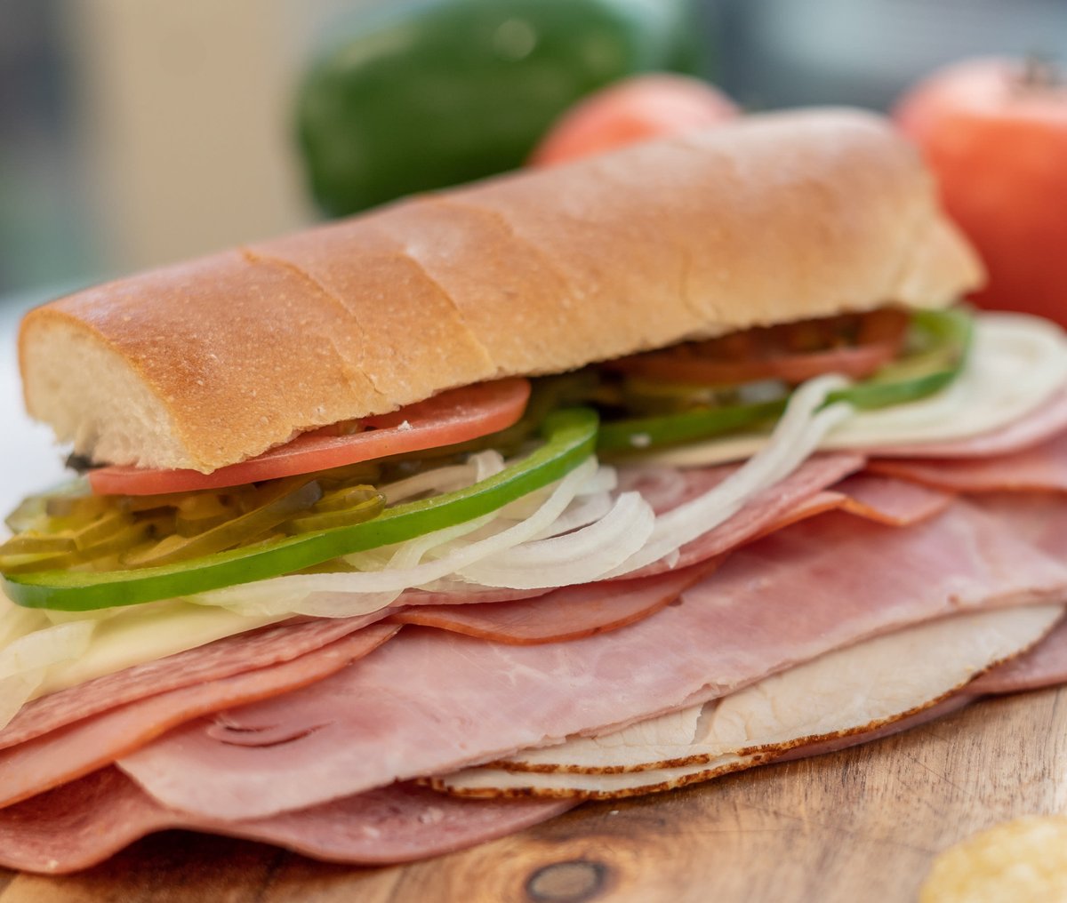 Sub sandwich with meat, peppers, onions, and tomatoes