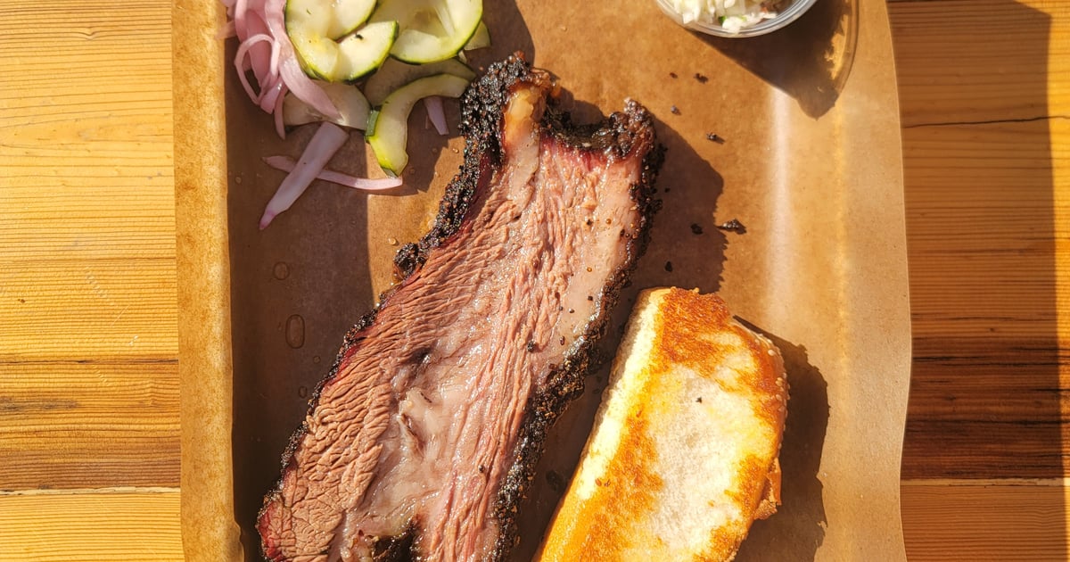 Close-up of brisket and pickled onions on a tray.