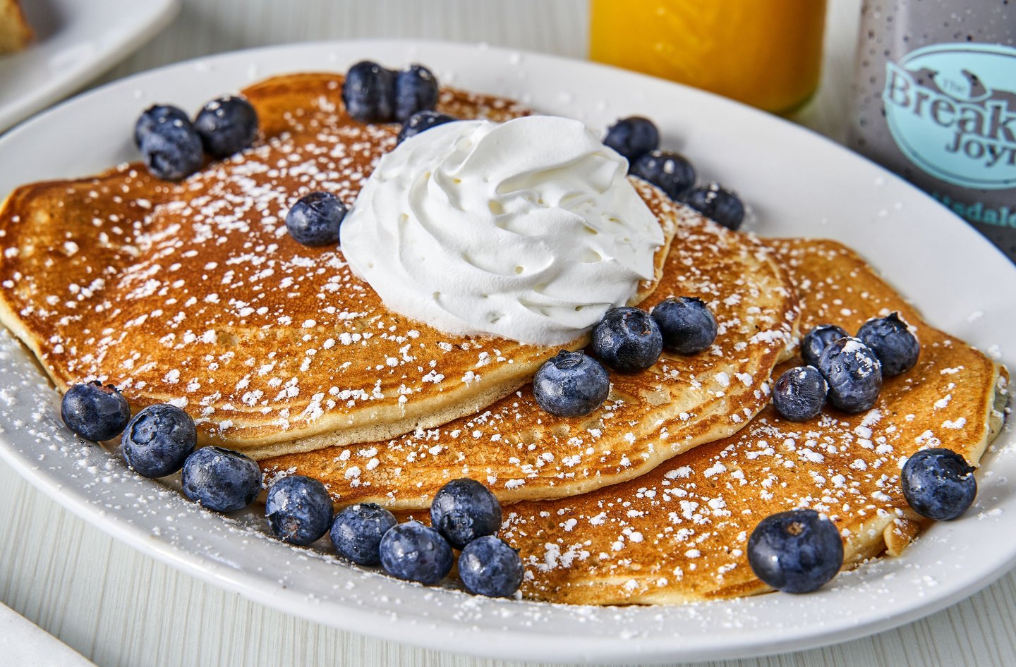 three pancakes topped with blueberries and whipped cream