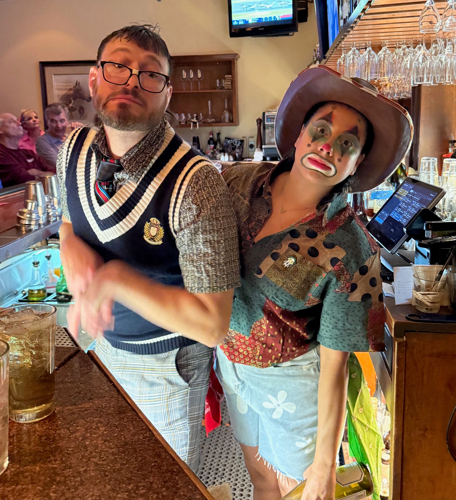 two people behind a bar dressed in Halloween costumes