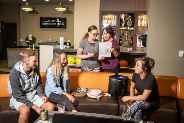Family laughing and enjoying conversation while reviewing a menu