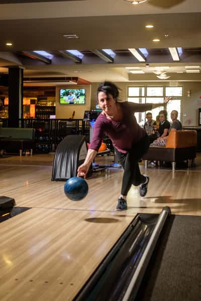 Woman throwing a bowling ball down a lane