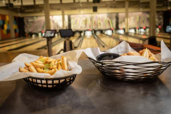 Fries sitting on a table with a bowling alley in the background