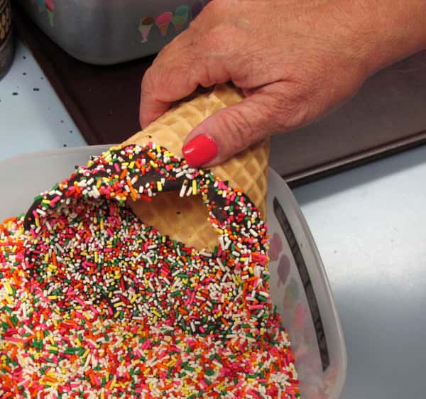 dipping waffle in sprinkles