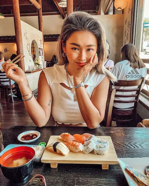 Woman enjoying sushi at Katsuya