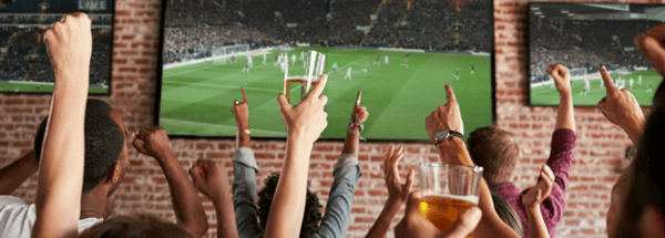 People cheering while watching football game on TV