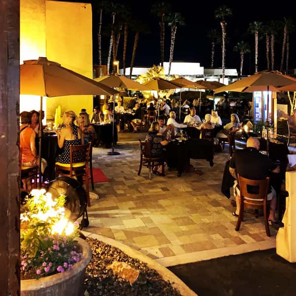 Outdoor dining tables with umbrellas front courtyard