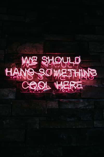 Neon pink sign that says We should hang something cool here