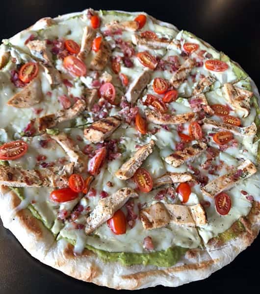 Pizza with chicken, tomatos, guacamole
