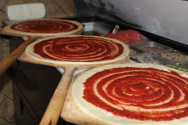 pizzas being made