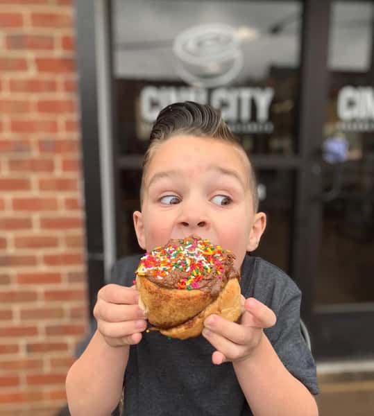 child eating an cinnamon roll