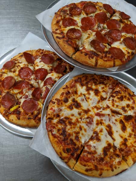 Three pizzas on platters