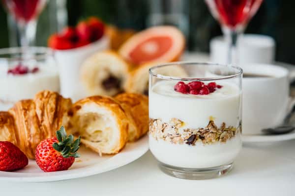 Yogurt parfaits with strawberries, granola, and pastries