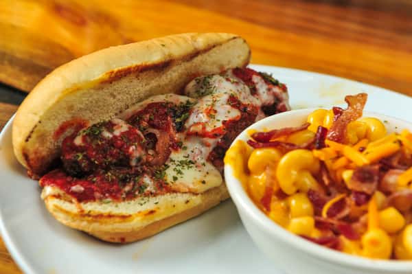 Hand rolled meatball sub with a side of mac n cheese