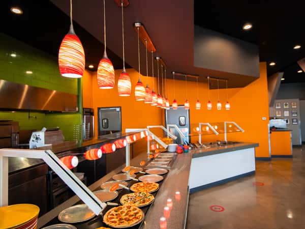 Food bar lined with pizzas and various meal options