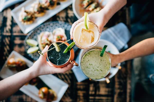 Friends cheering with different cocktails