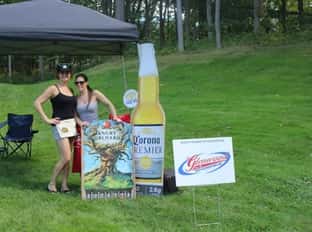 two people on golf course next to beer signs