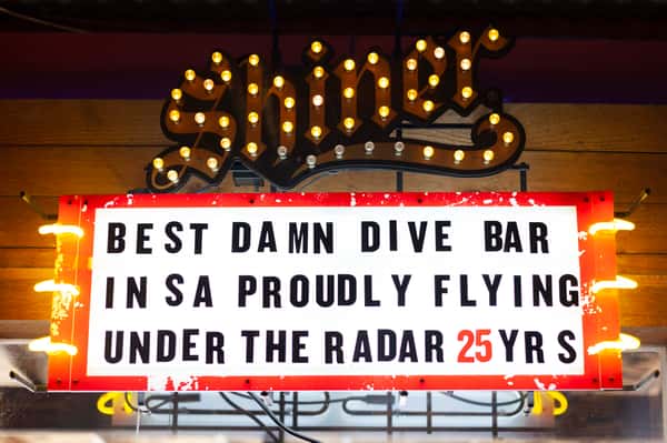Sign that says best damn dive bar in San Antonio proudly flying under the radar 25 years
