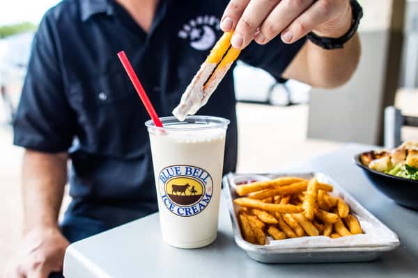 Man dipping moonie's fries into a moonie's shake