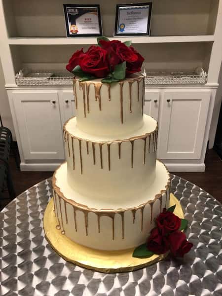 wedding cake with gold drip and roses