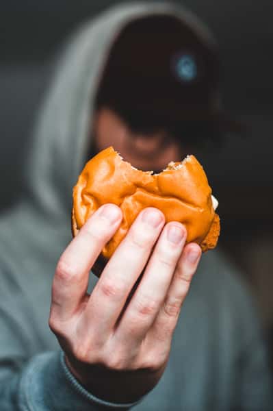 Man holding out a sandwich